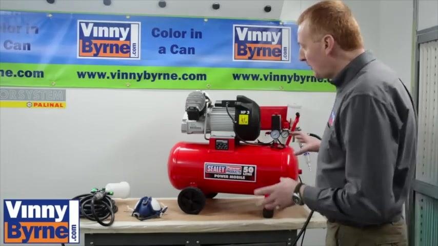 Spray gun with filter attachment, hose and mask visible on the table