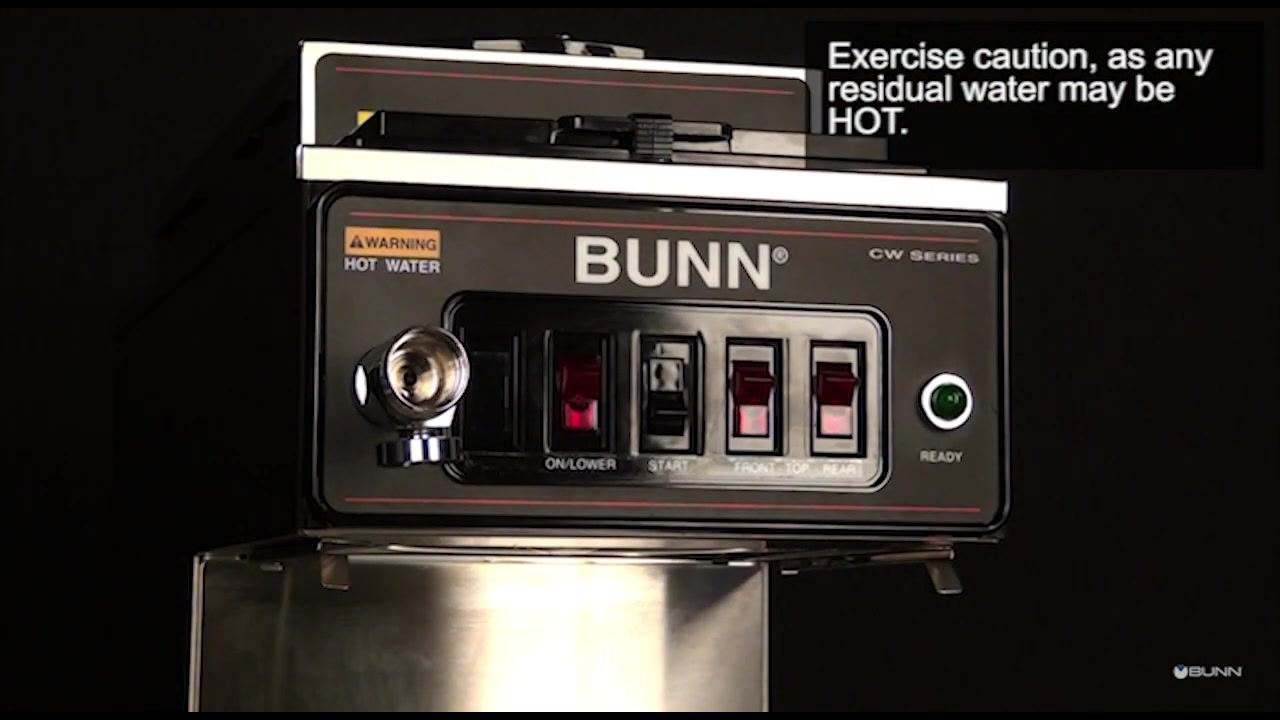 The faucet handle and bonnet nut are removed, exposing the faucet stem. On-screen text: "Exercise caution, as any residual water may be HOT."