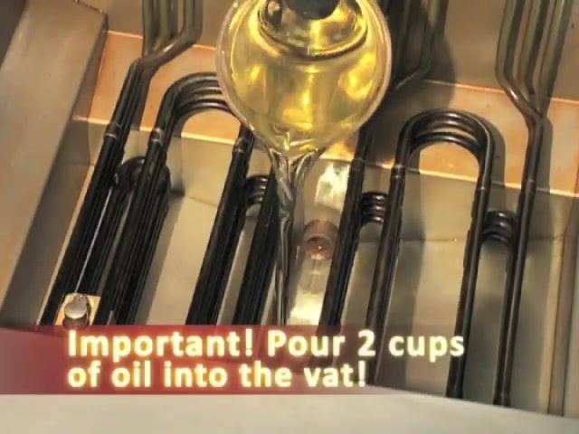 A person pours oil from a measuring cup into the fryer vat. On-screen text reads: "Important! Pour 2 cups of oil into the vat!"