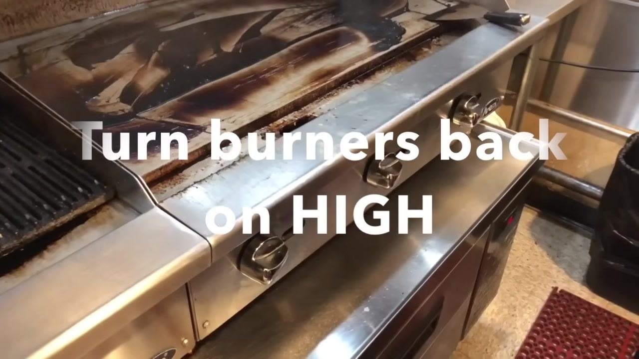 A clean grill surface with burner knobs visible. On-screen text reads "Turn burners back on HIGH."