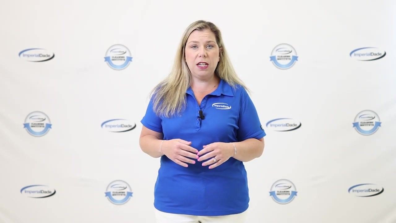 Presenter explaining the number and function of baffles, wearing blue ImperialDade shirt, standing in front of branded backdrop