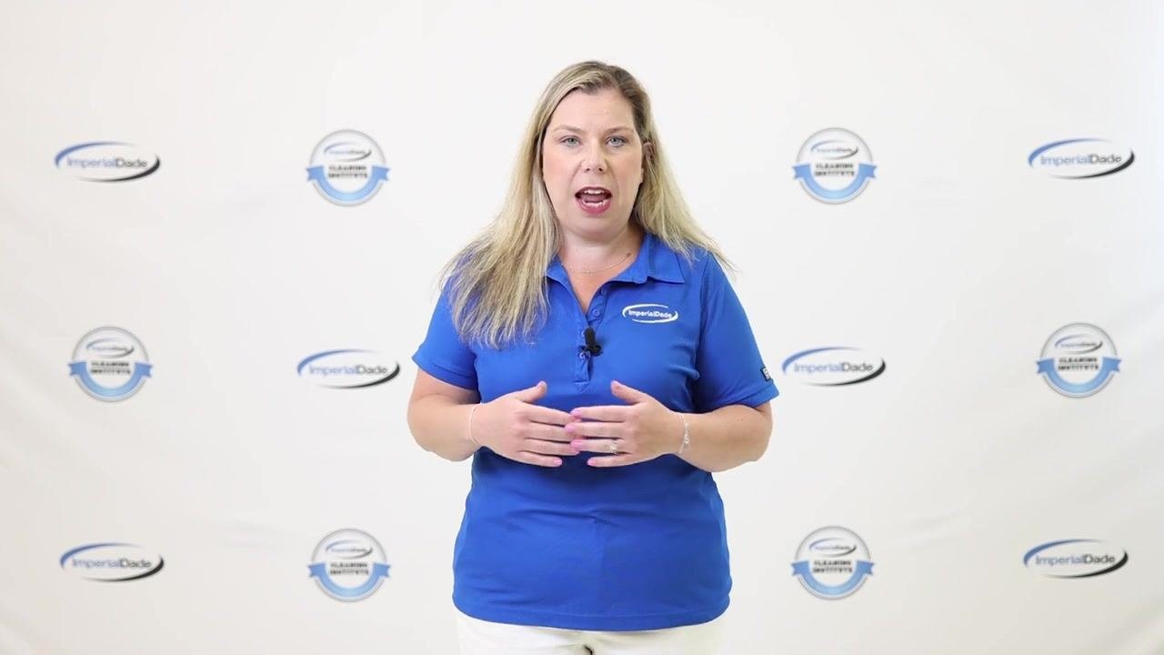Presenter explaining cleaning of tank walls, lid, and baffles, wearing blue ImperialDade shirt, standing in front of branded backdrop
