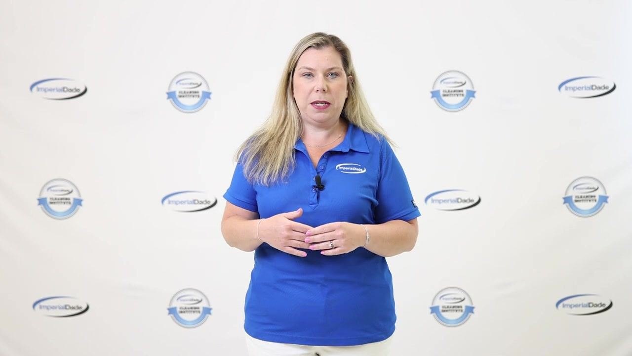 Presenter explaining lid removal, wearing blue ImperialDade shirt, standing in front of branded backdrop