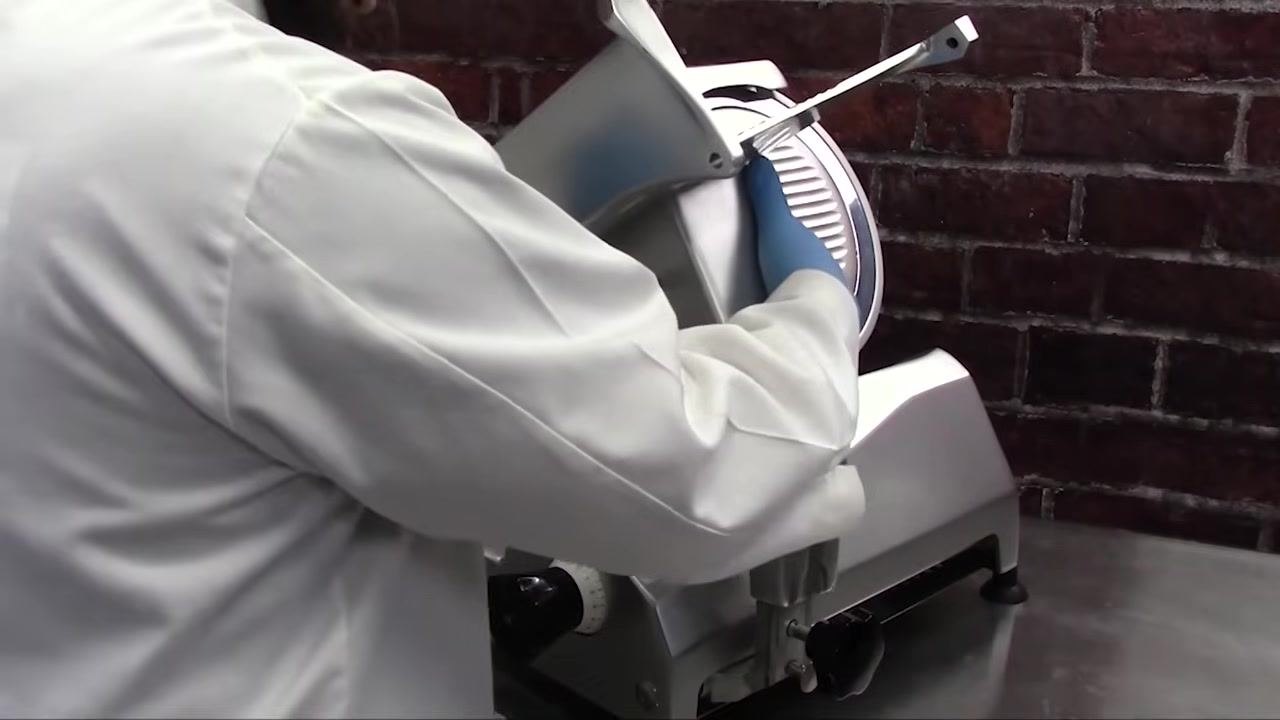 Close-up of the product feed rod and washer assembly being inserted through the carriage, with the washer positioned against the carriage wall.