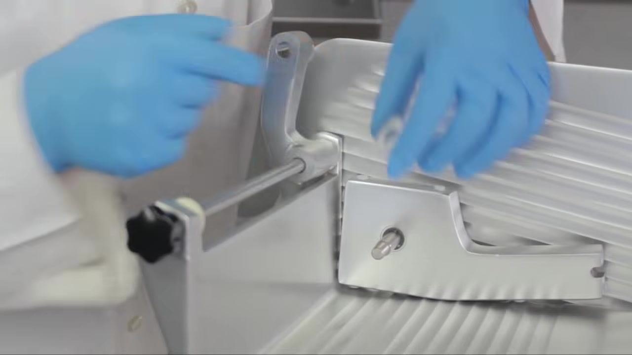 Operator positioning the thin plastic spacing washer onto the feed grip rod, ensuring proper placement.