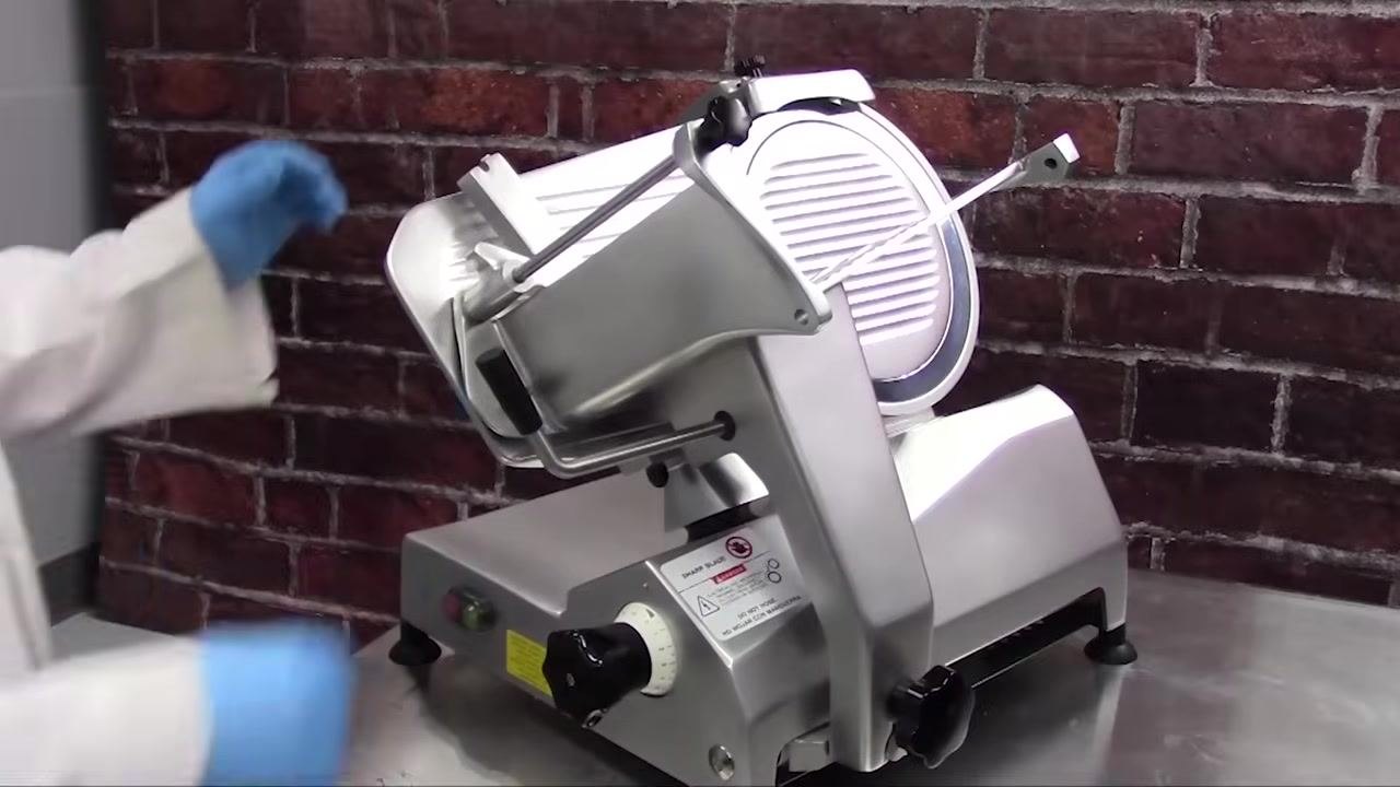 Operator loosening the adjustment spacer knob on the slicer.