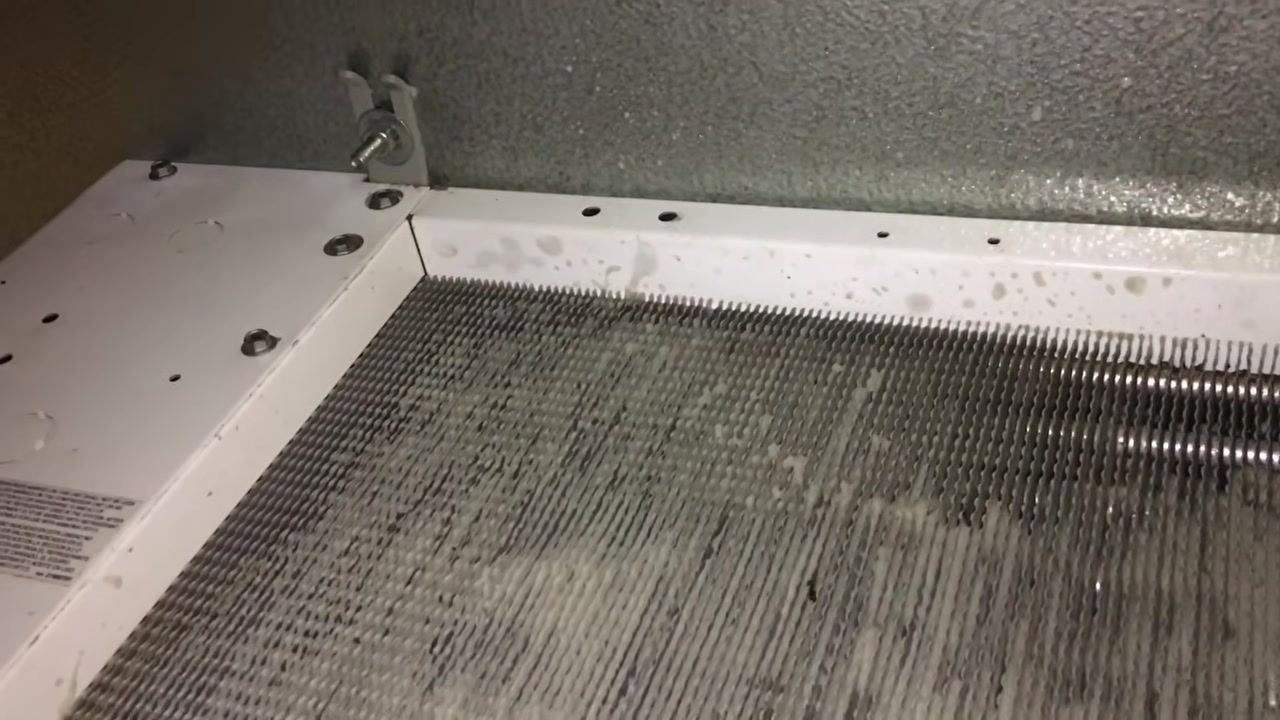 Close-up of HVAC coil and metal frame showing water spots and residue before cleaning