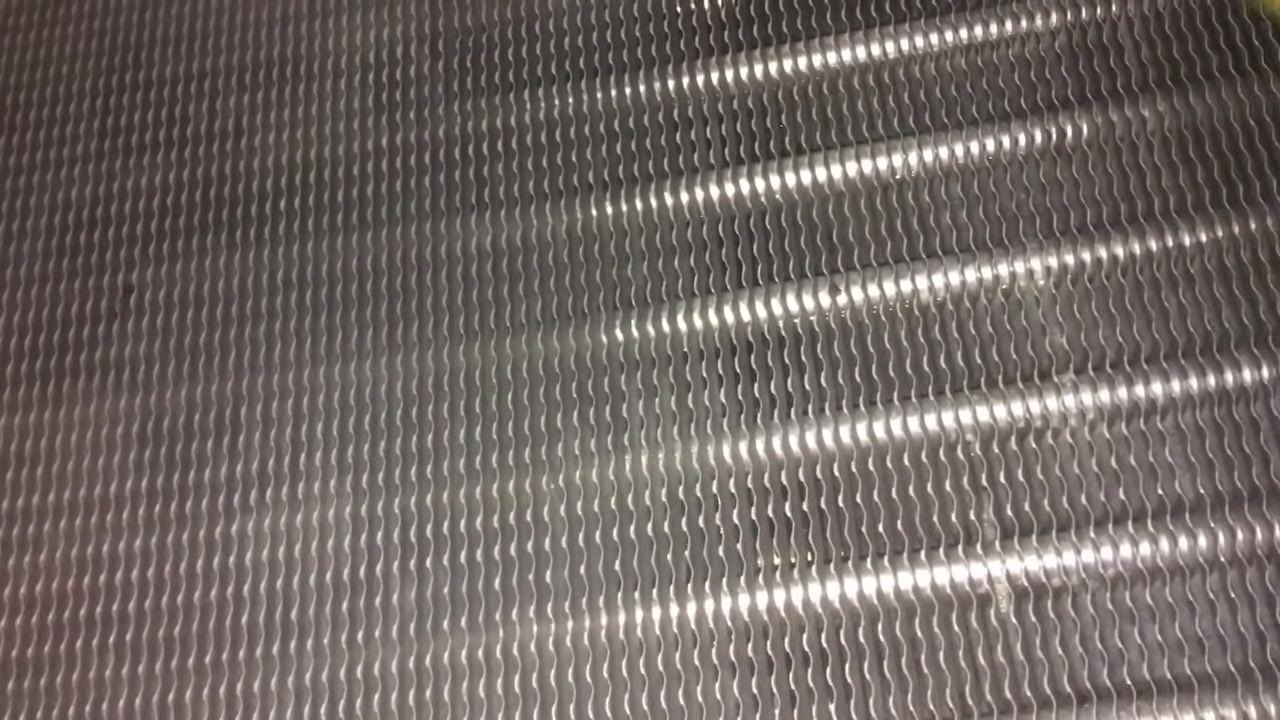 Heat exchanger tubes, clean and metallic, with some water droplets visible