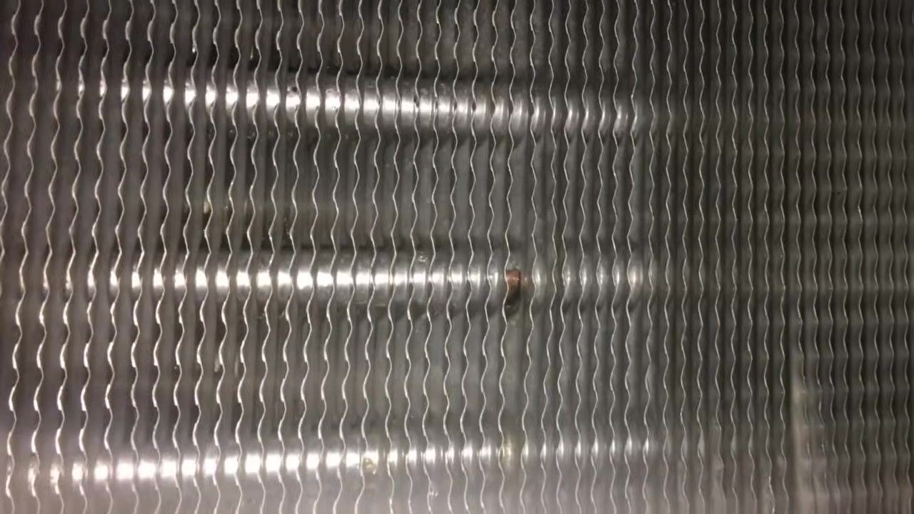 Close-up of evaporator coil fins showing a clean, metallic surface with uniform wavy patterns