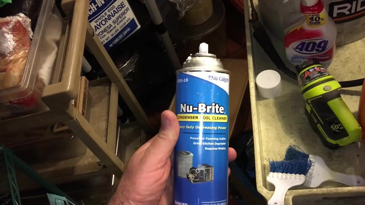 Vacuum cleaner and cleaning supplies, including a sprayer and brushes, staged for use