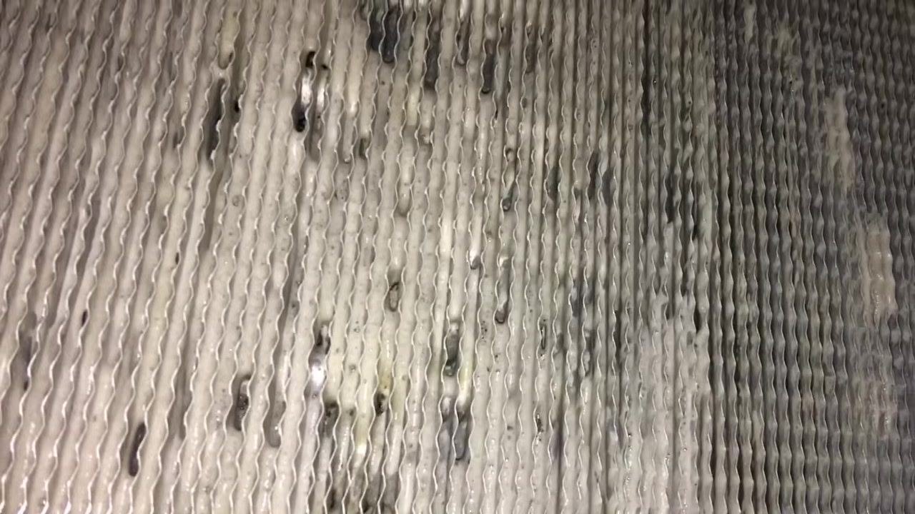 Evaporator coil fins after brushing, showing cleaner residue and improved cleanliness