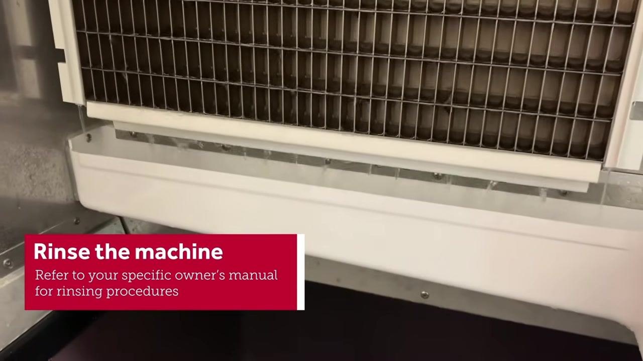 Person wearing yellow gloves using a blue cloth to clean the evaporator grid inside the machine, with the on-screen instruction "Clean the evaporator, probe & water trough"