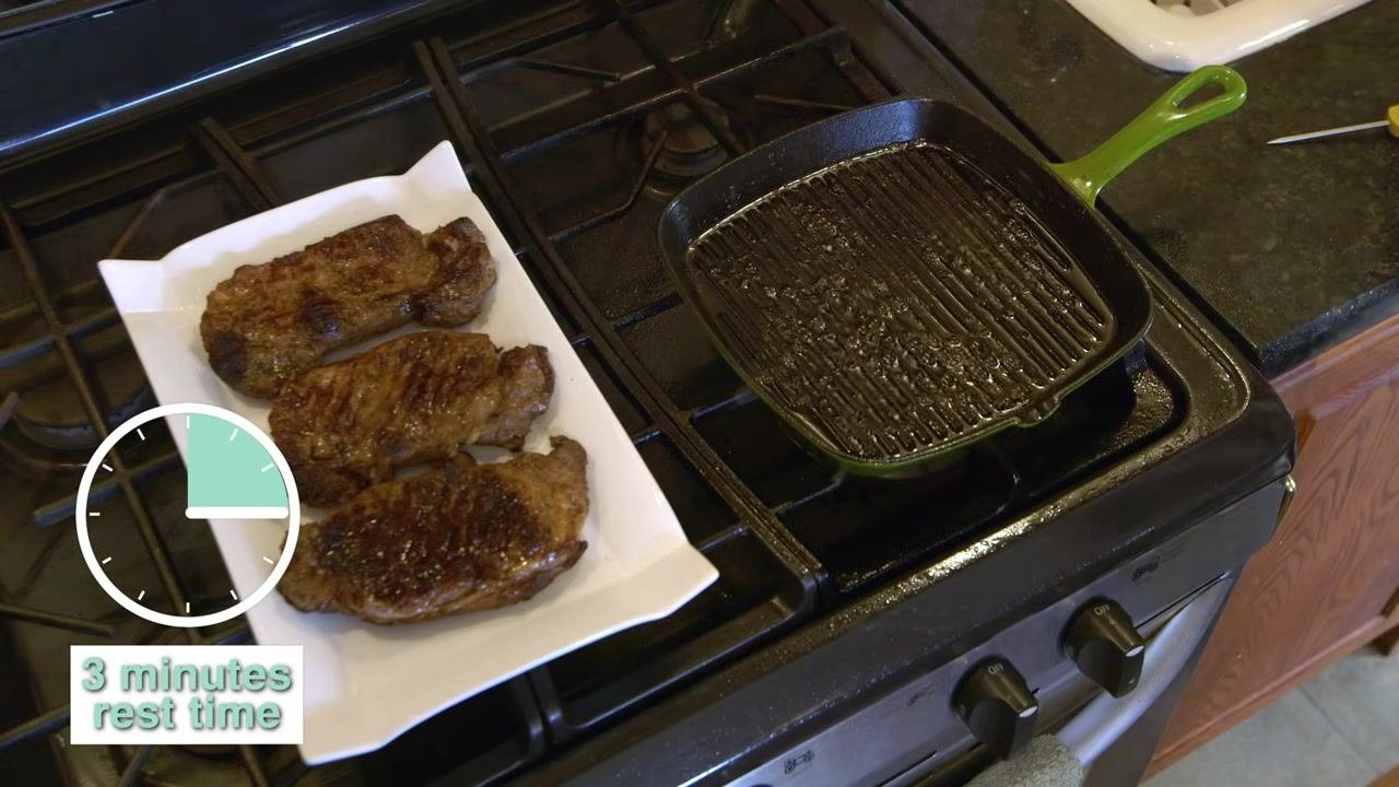 A family of three seated at a dining table, enjoying a meal that includes cooked steaks