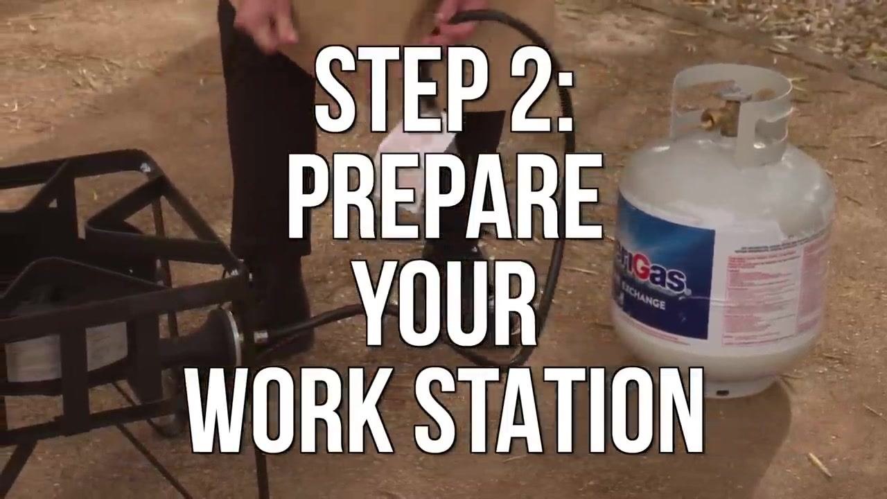 A person lowers a turkey into a large fryer pot filled with water outdoors.