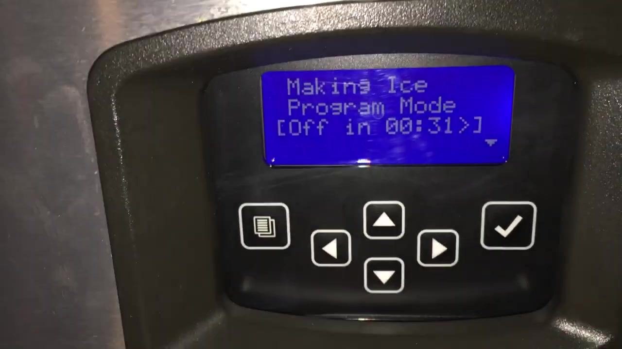 Hand pointing at a full ice bin with visible ice and residue on the bin edge
