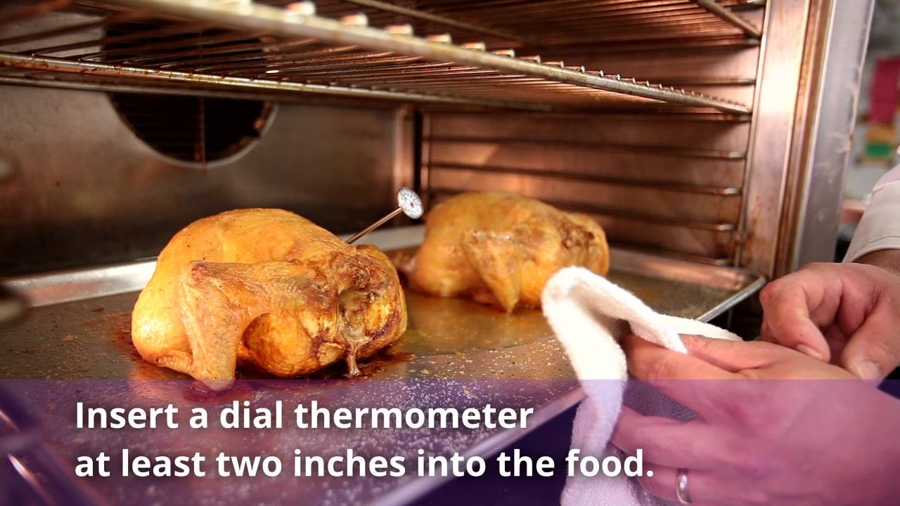 Cooked chickens in an oven with a dial thermometer inserted at an angle, with text noting that a dial thermometer should go at least two inches into the food.