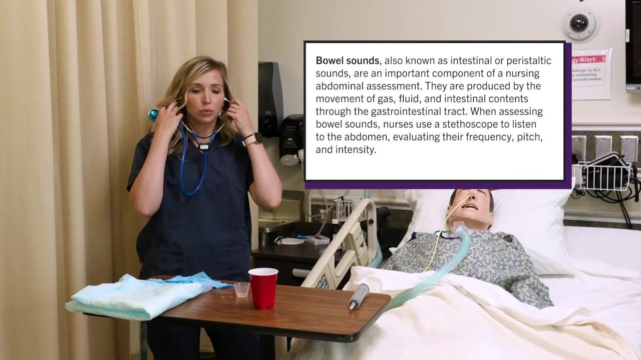 Nurse placing stethoscope earpieces in her ears before listening to the patient's abdomen, with on-screen text describing bowel sound assessment. Patient mannequin with NG tube is in the bed.