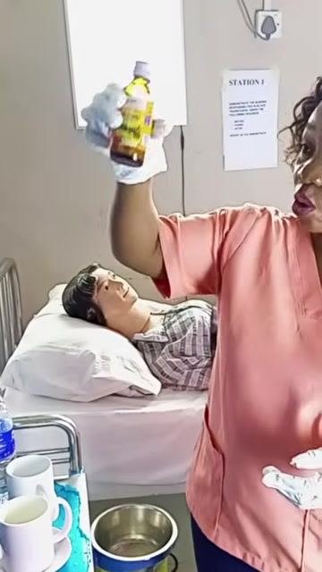 A healthcare worker holding a bottle of syrup up to the light to check its color and clarity before administration.