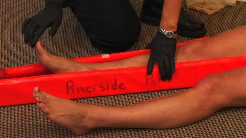 A responder checks the patient's foot for pulse and sensation, with the splint in place along the leg.