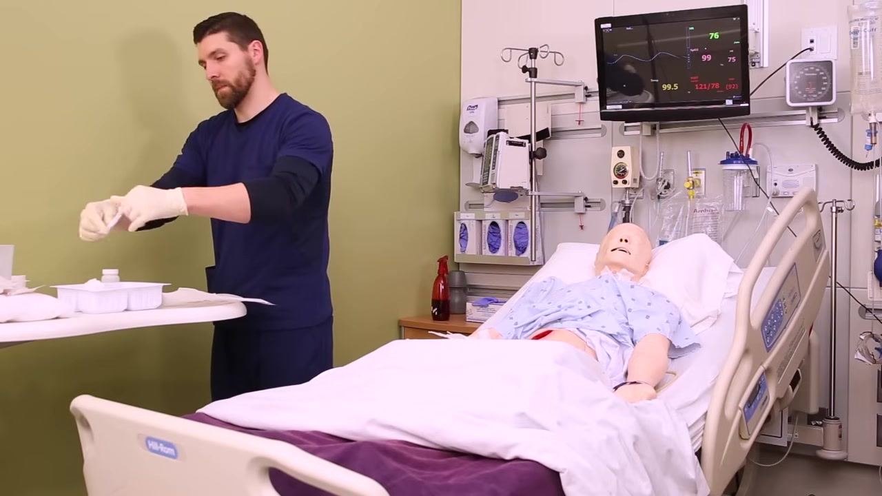 Nurse picking up and wringing out a piece of saline-soaked gauze over a sterile tray, maintaining sterile technique
