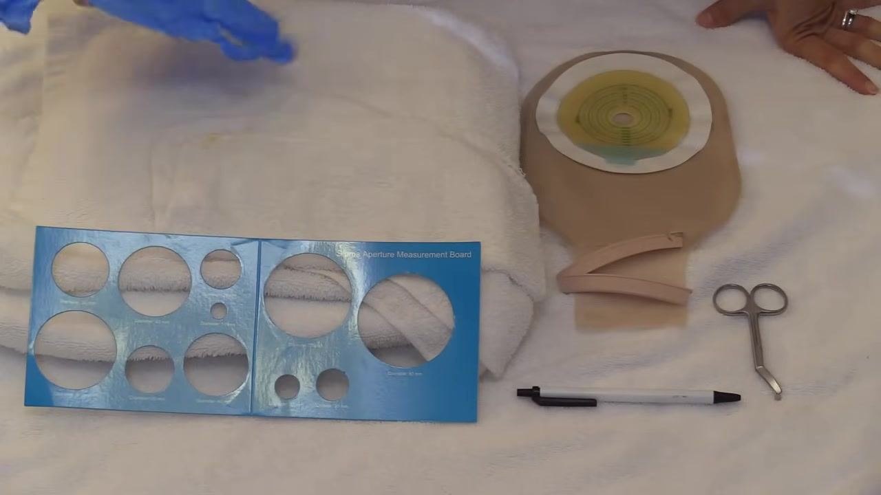 All supplies arranged on a towel: gloves, measurement board, folded towel, pouching system, clip, pen, and scissors