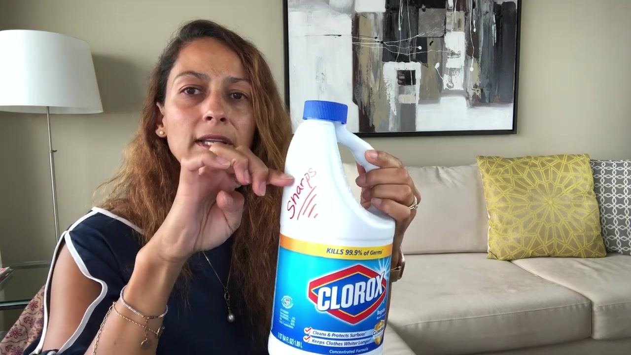 Person screwing the blue lid onto the labeled bleach bottle, demonstrating how to securely seal the homemade sharps container.