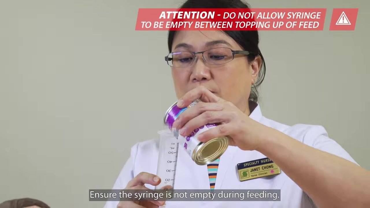 Oral nutrition supplement being poured from a can into a syringe connected to the feeding tube