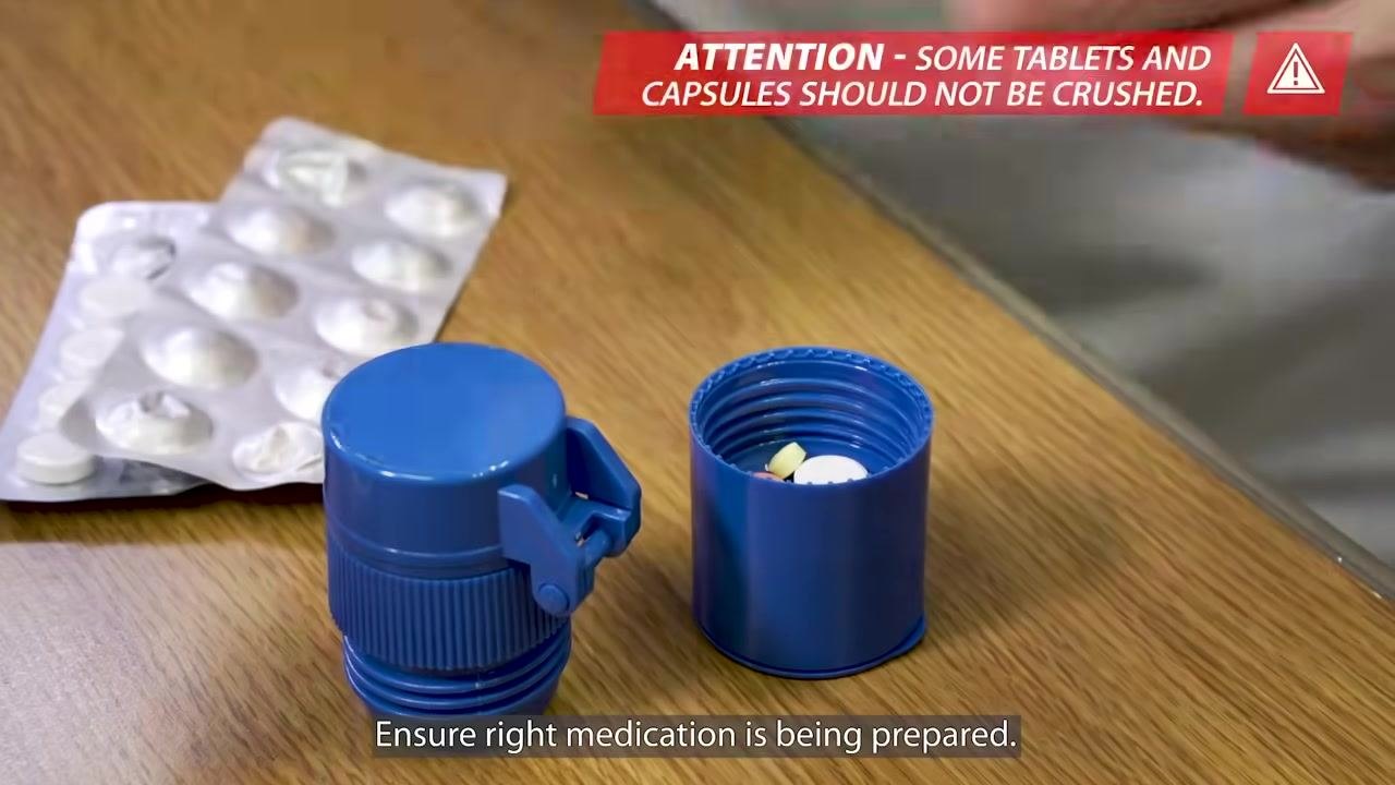 A syringe being prepared to flush the feeding tube with water before medication