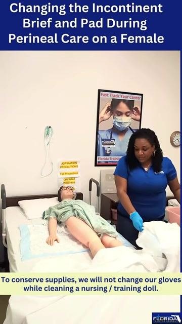 The mannequin patient is turned on her side, exposing the backside for cleaning, with the caregiver ready with supplies and privacy maintained.