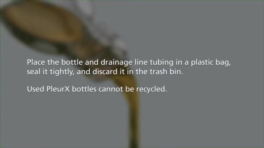 Close-up of the drainage bottle's cap and attached tubing, with the detachment point highlighted.