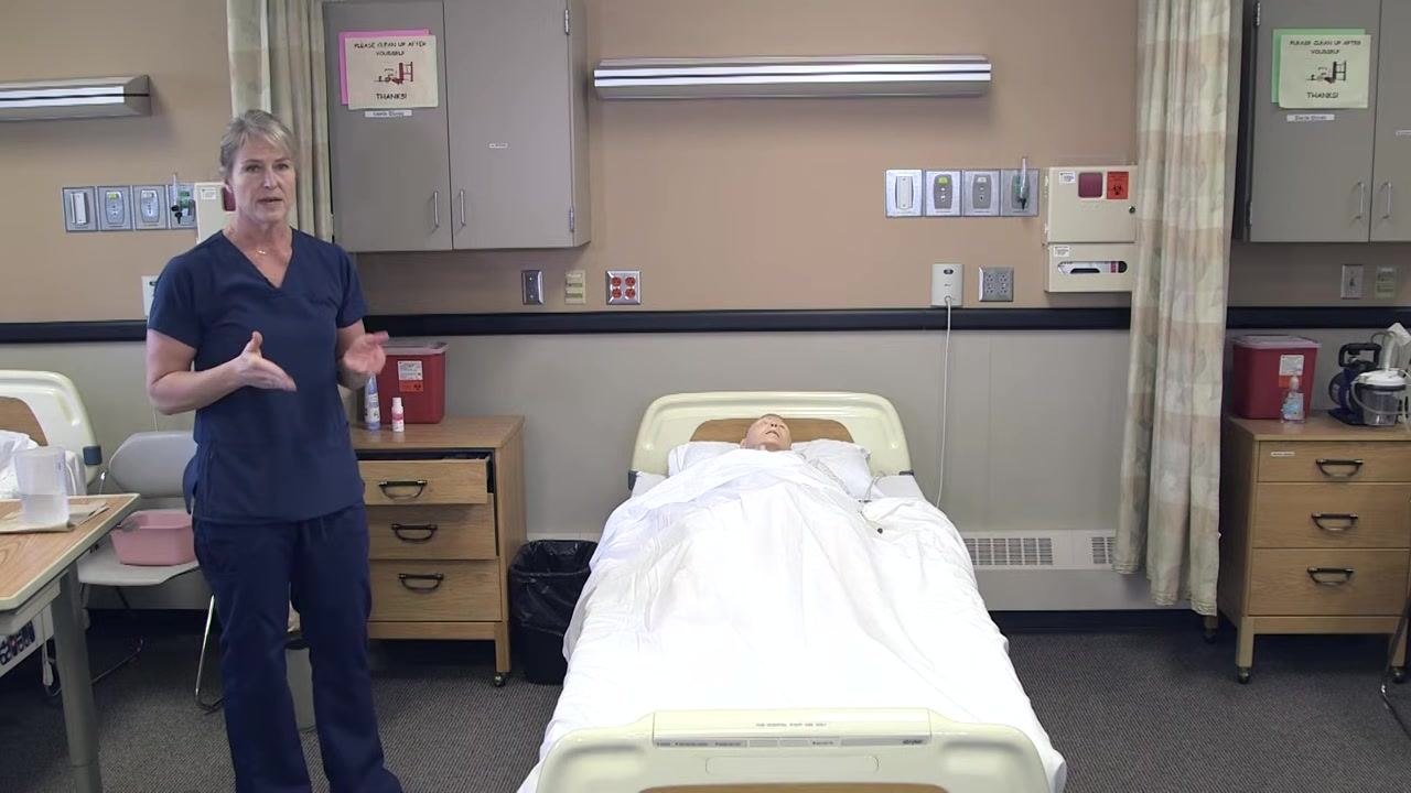Nursing assistant removing gloves after disposing of urine, with the graduated cylinder and supplies visible on the overbed table