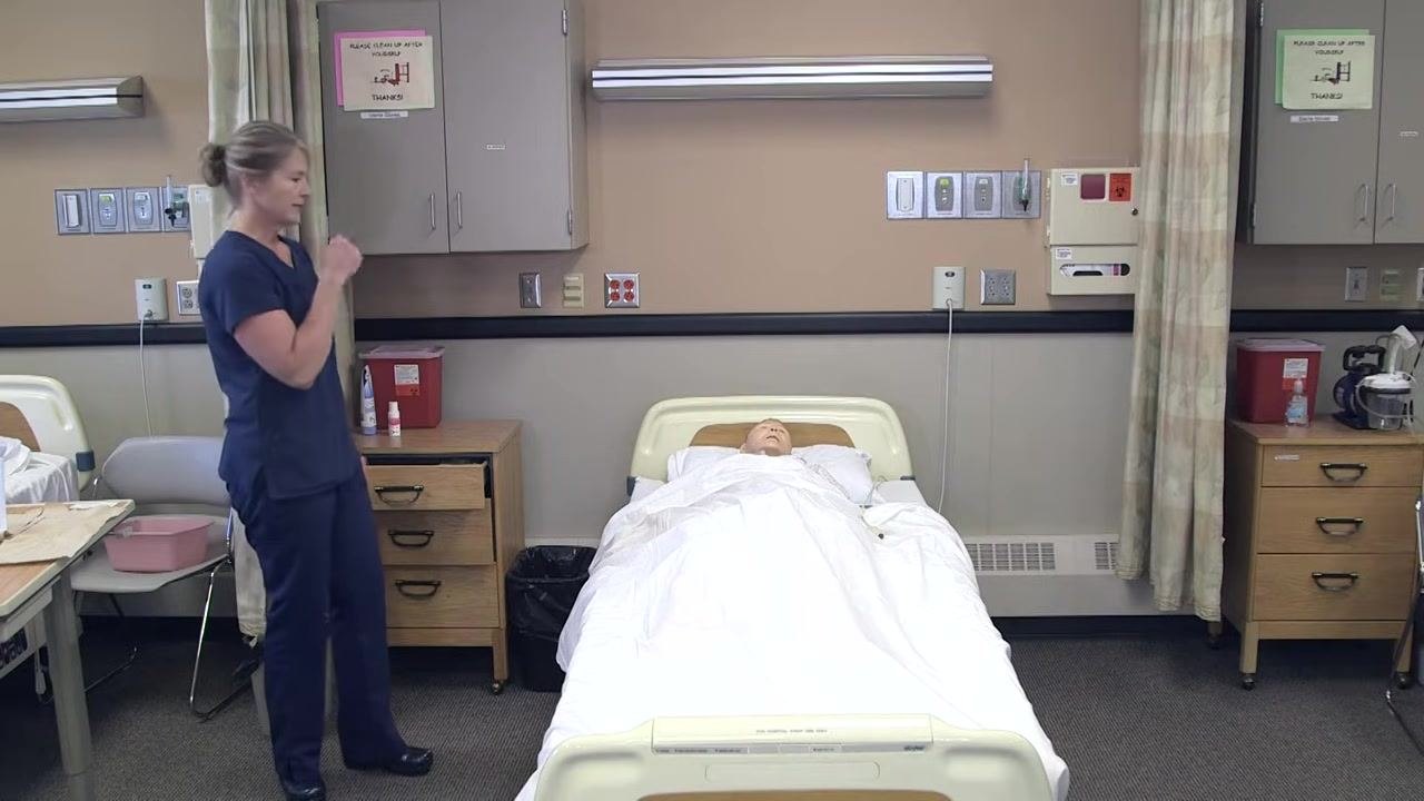 Nursing assistant adjusting the bed and positioning the catheter bag so it does not touch the floor