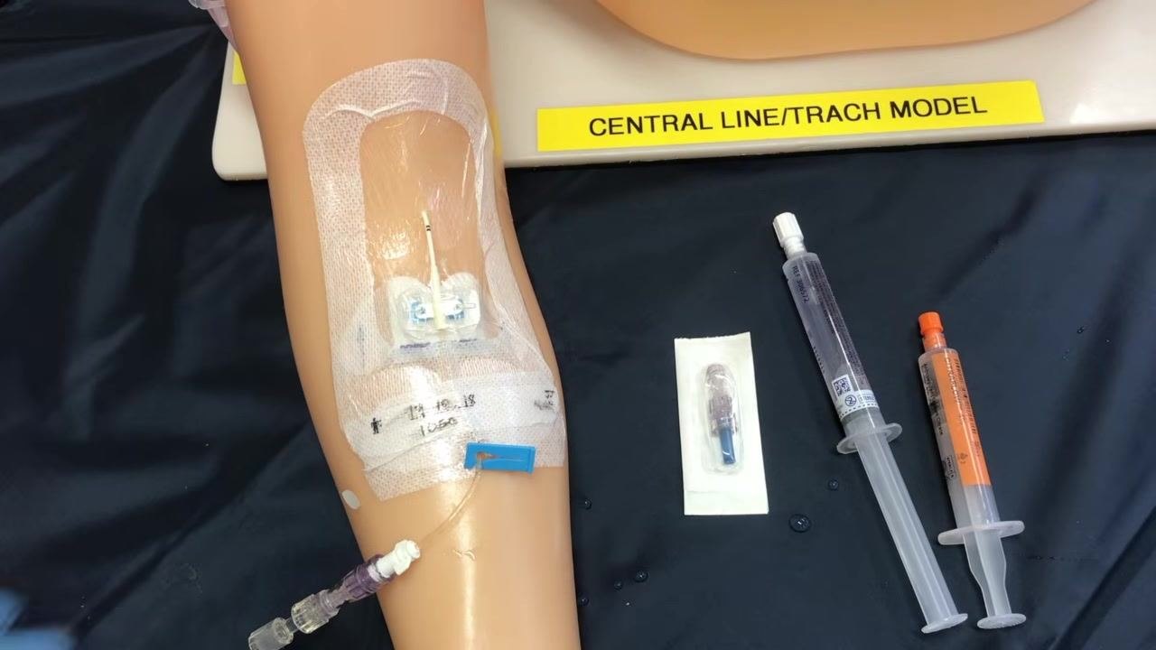 Hands connecting the medication or infusion line to the neutral cap of the PICC line using a push-and-twist motion