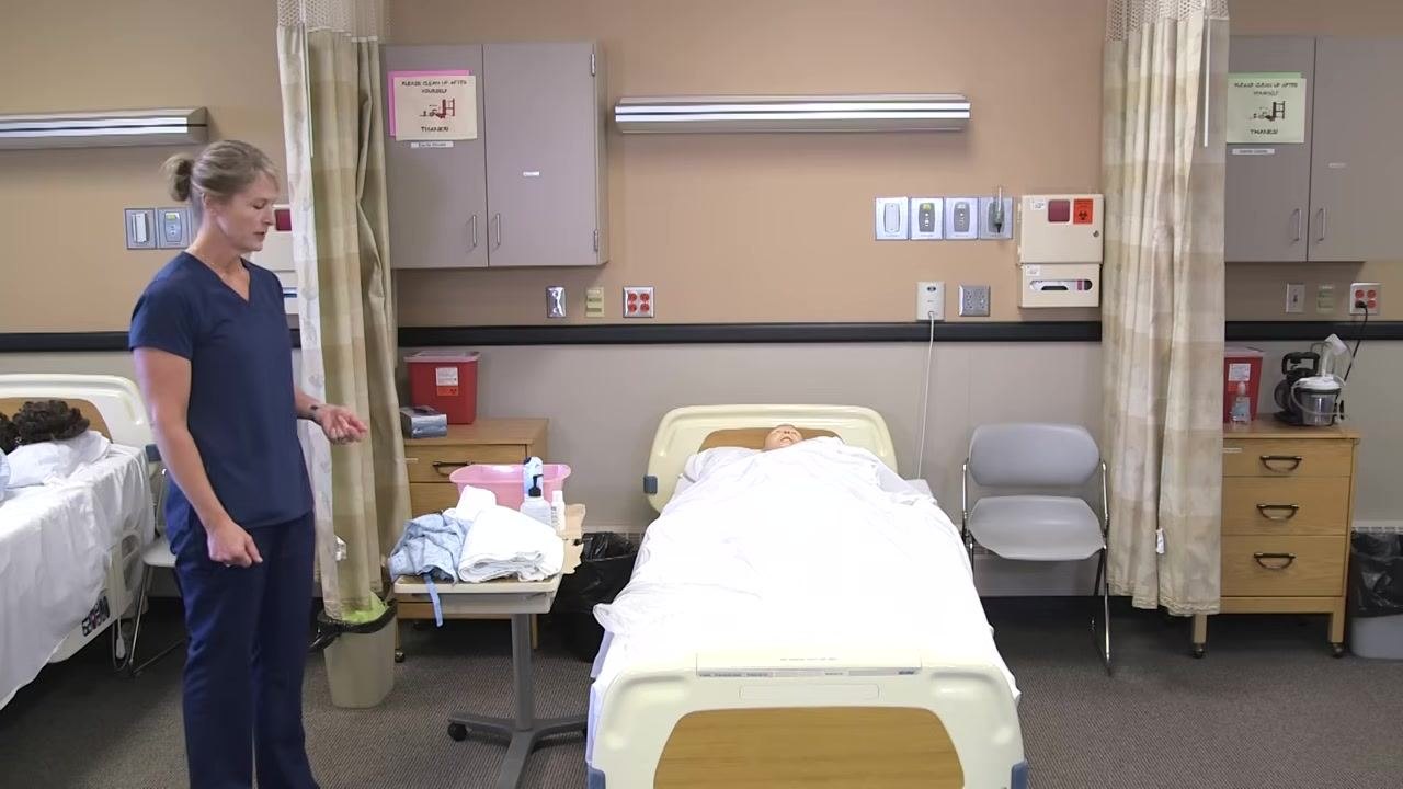 Nurse in blue scrubs pulling the privacy curtain around the bed, preparing for the procedure.