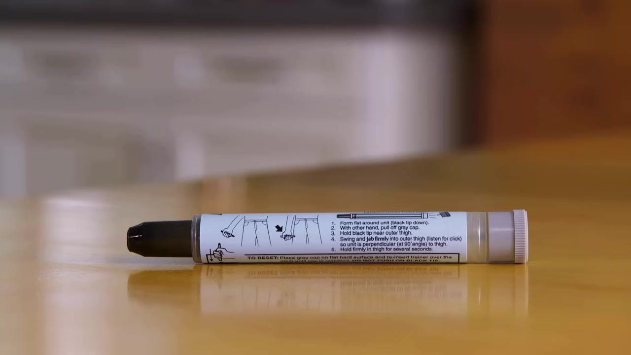 A single vial of sodium chloride injection with a yellow cap, standing on a table.