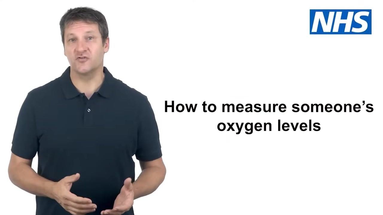 A person stands next to an image of a pulse oximeter clipped onto a finger, showing readings of SpO2: 98 and pulse: 64. The NHS logo is visible.