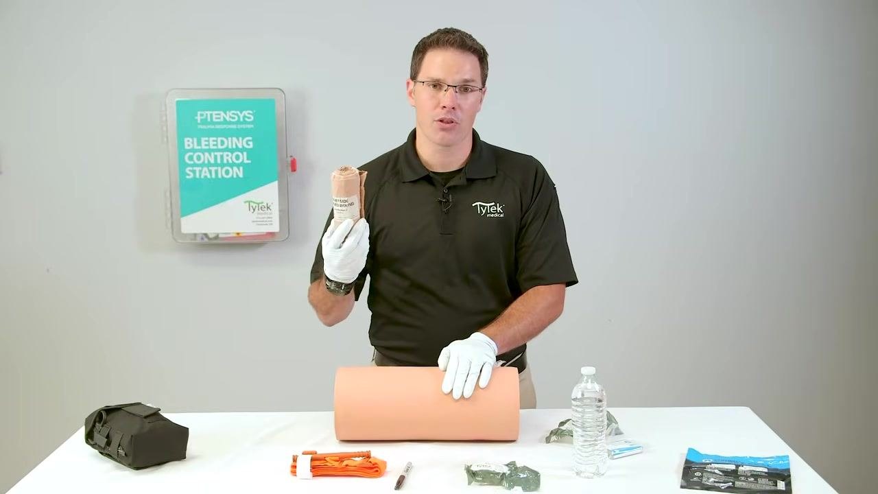Applying direct pressure with both hands over the packed wound.