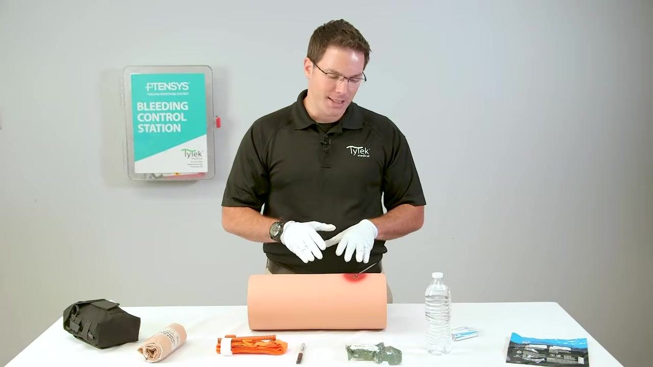 Pointing to the location of the active bleeding source within the wound.