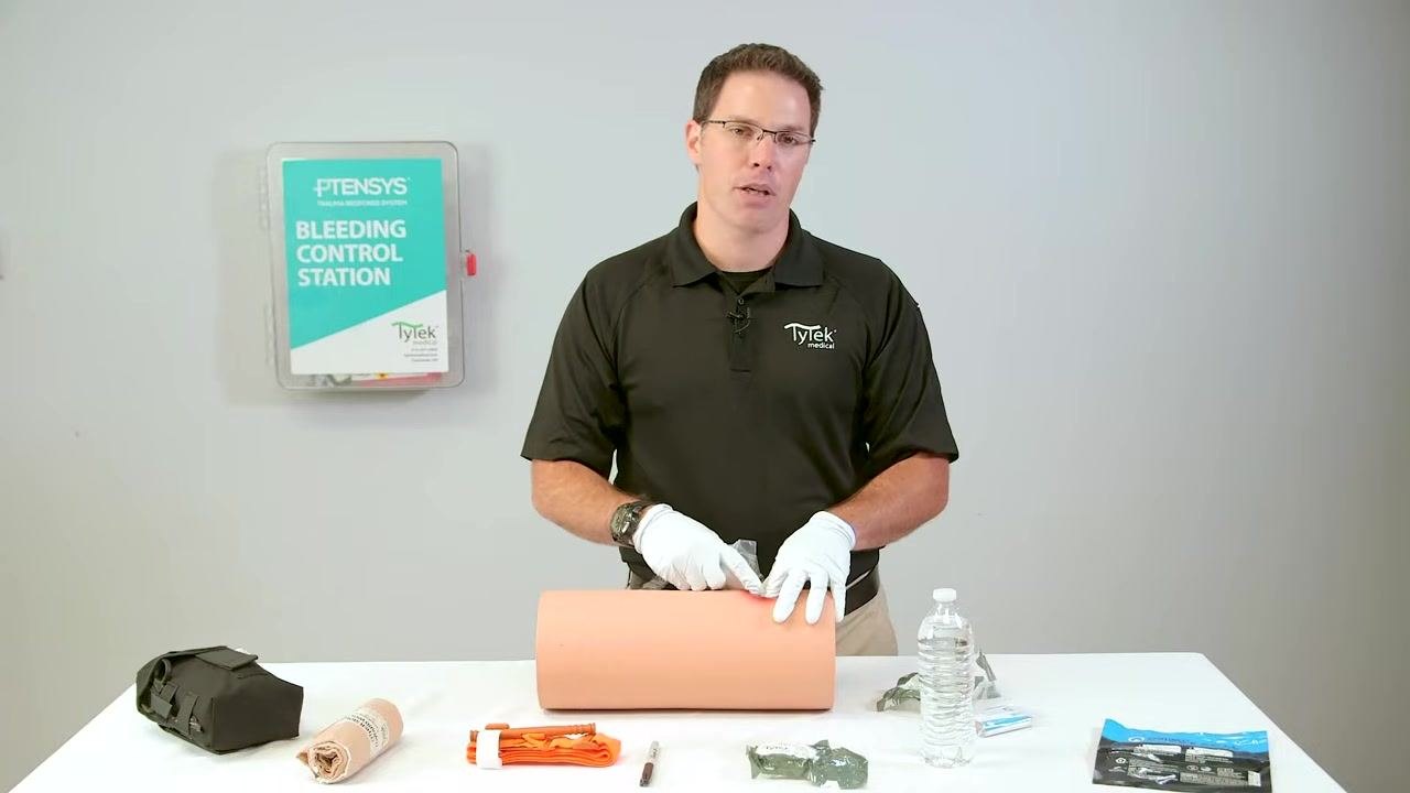 Maintaining pressure on the bleeding source while preparing to add more gauze.