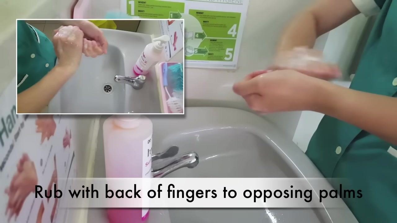 A person rubs their soapy hands palm to palm with fingers interlaced over a sink. The caption reads "Rub palm to palm with fingers interlaced."