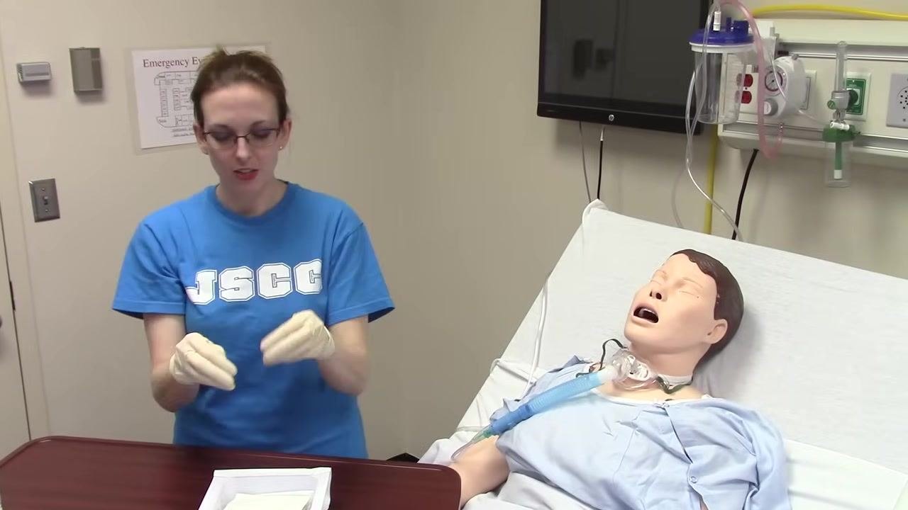 Both hands are now gloved and held above the sterile field, demonstrating proper sterile technique.