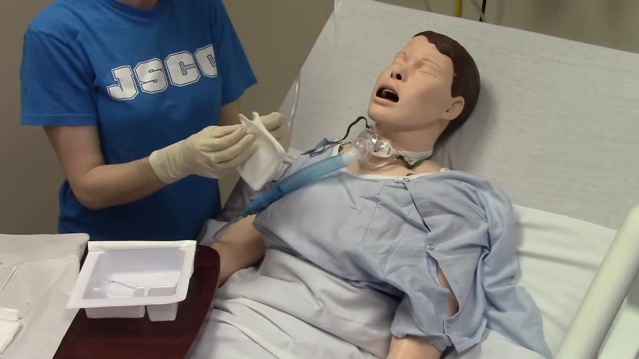 A piece of gauze is prepared for cleaning excess secretions around the tracheostomy site.