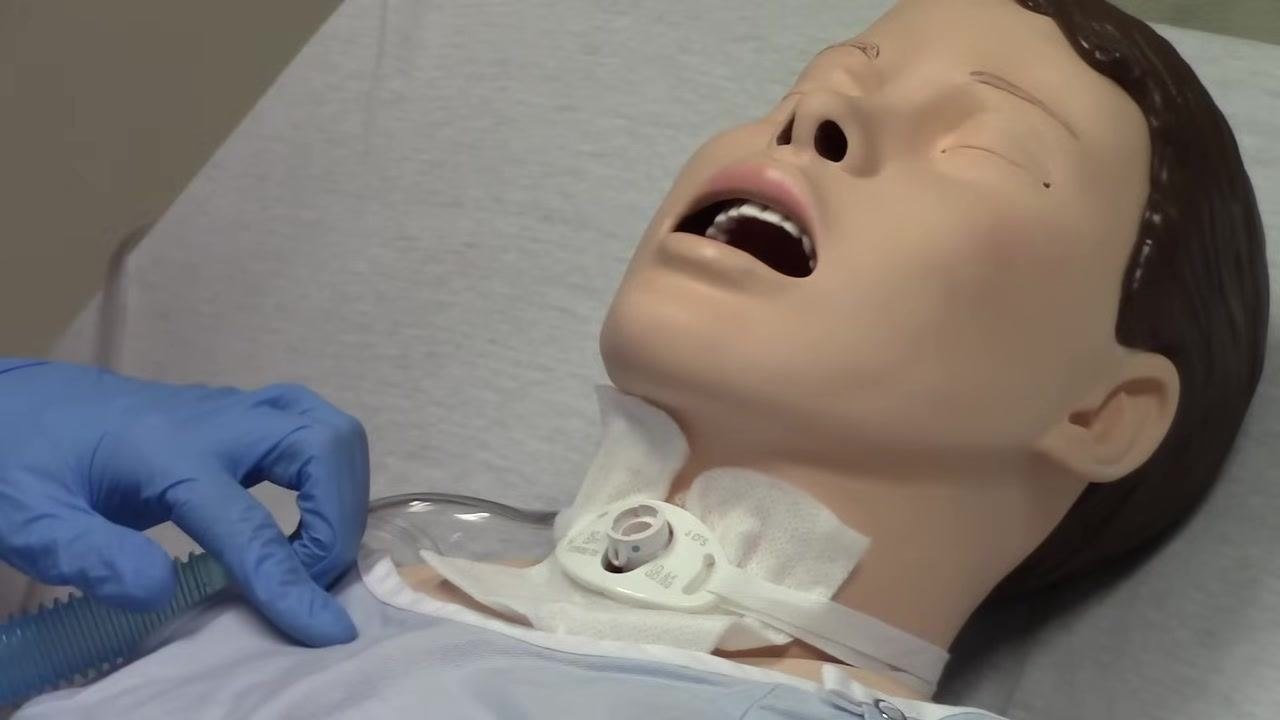 Trach tube with the inner cannula removed, showing the outer cannula remaining in place on the mannequin.