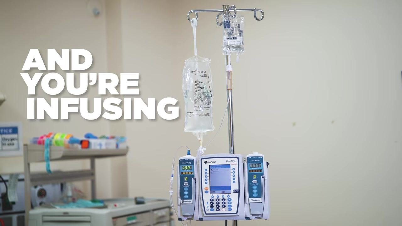 The Alaris PC and pump modules display the calculated secondary infusion parameters: RATE 100 mL/hr, VTBI 50 mL, DURATION 30 min, DOSE 2,000 mg.