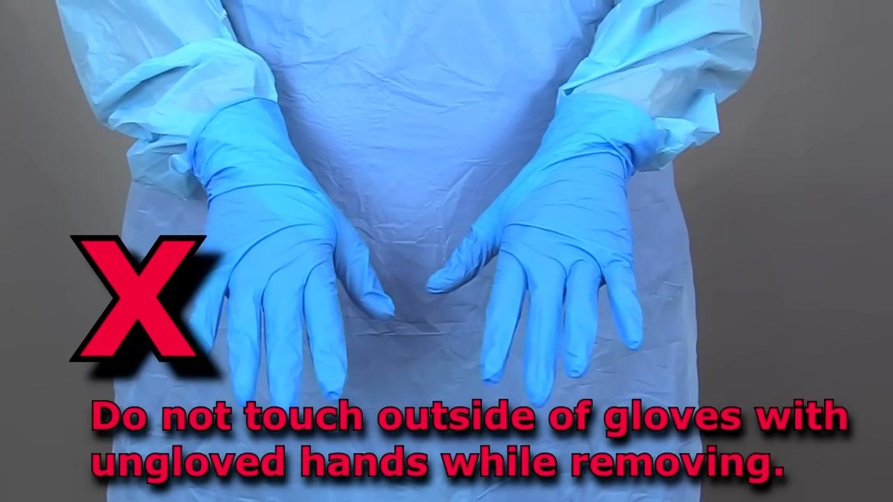 Close-up of one gloved and one ungloved hand, with the ungloved finger sliding under the cuff of the remaining glove