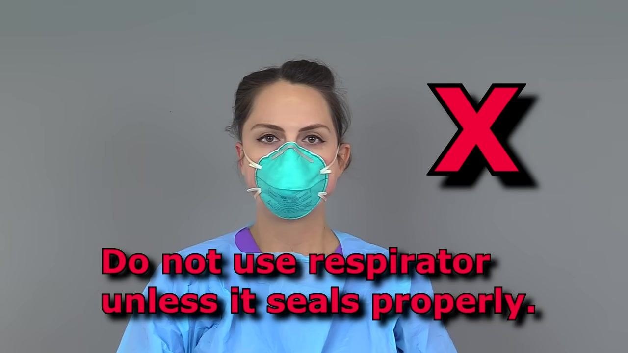 Nurse holding goggles in front of her face, preparing to put them on over her N95 respirator