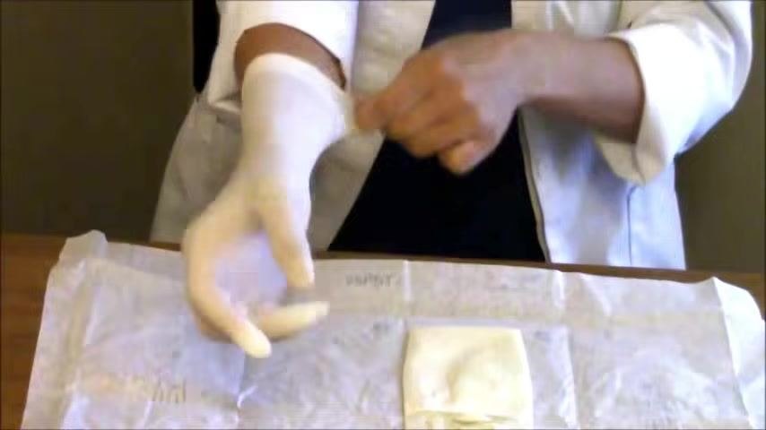 The right glove is adjusted up the arm for a secure fit while the left glove remains untouched on the wrapper.