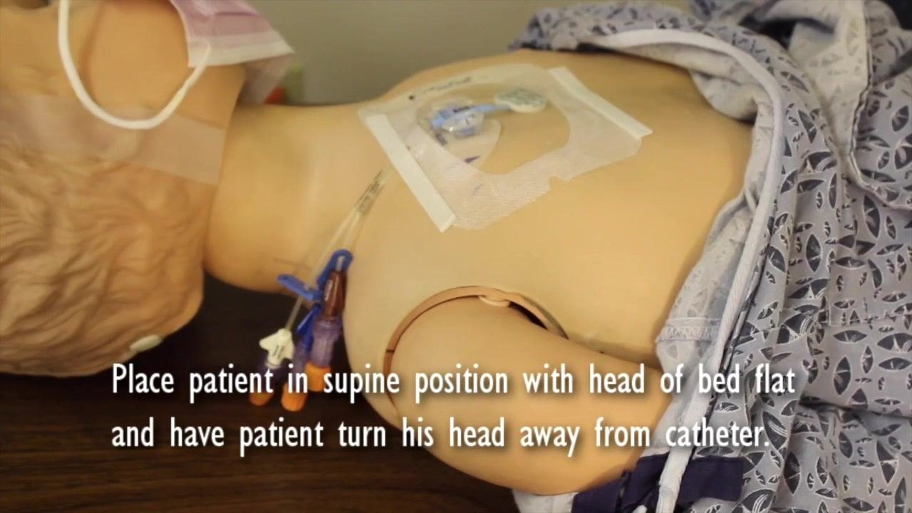 Patient mannequin in supine position with head turned away from the catheter. Text: "Place patient in supine position with head of bed flat and have patient turn his head away from catheter."
