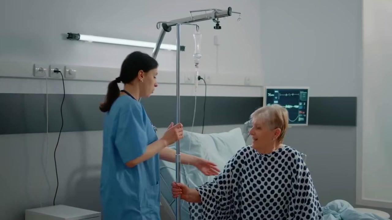 Gloved hands holding the removed catheter and inspecting it for integrity, with the mannequin visible