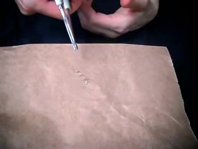 Hands holding a staple remover above the wound, focused on careful inspection during removal.